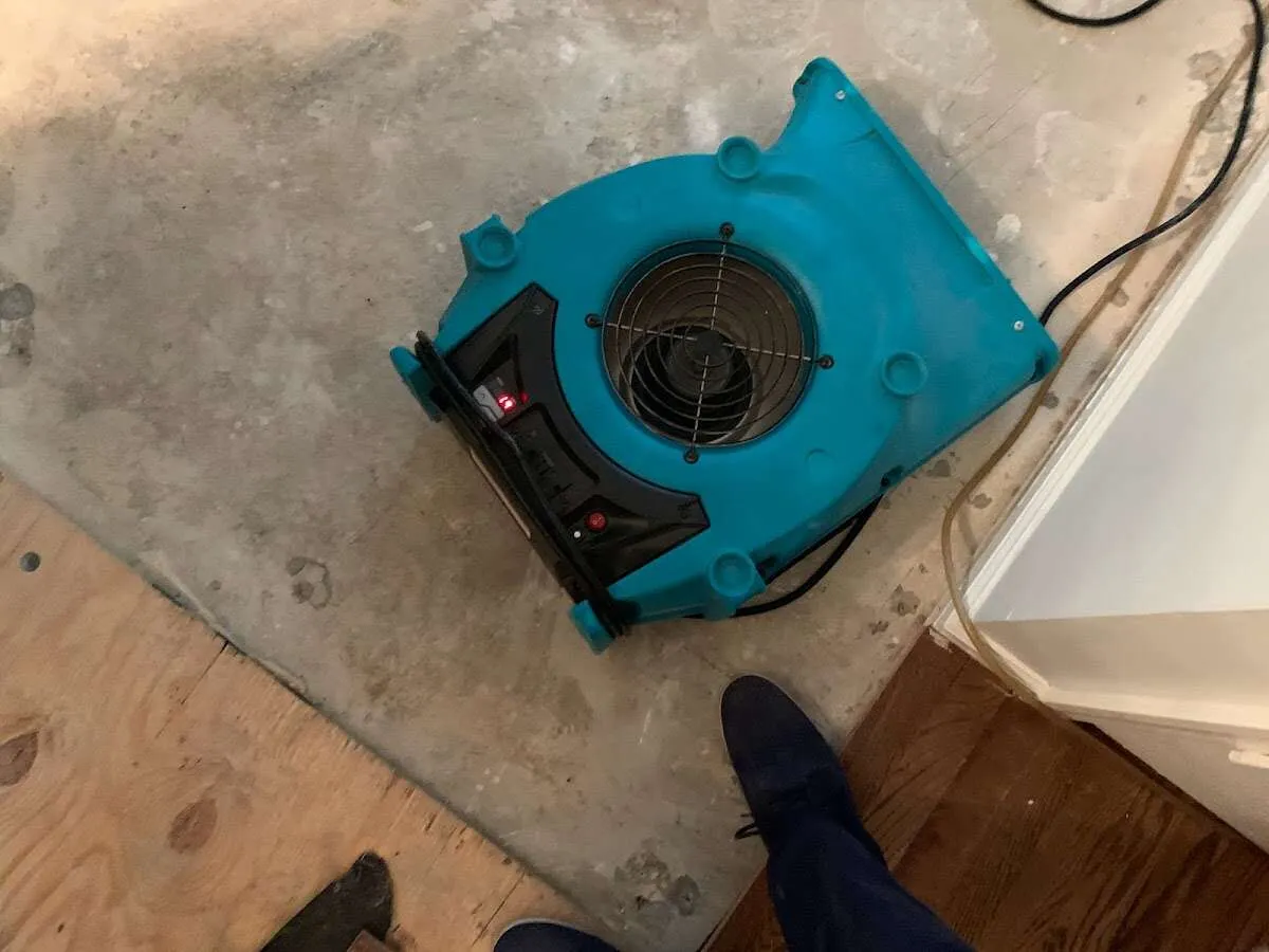 Air mover drying subfloor during Commercial Water Damage Restoration in Atoka